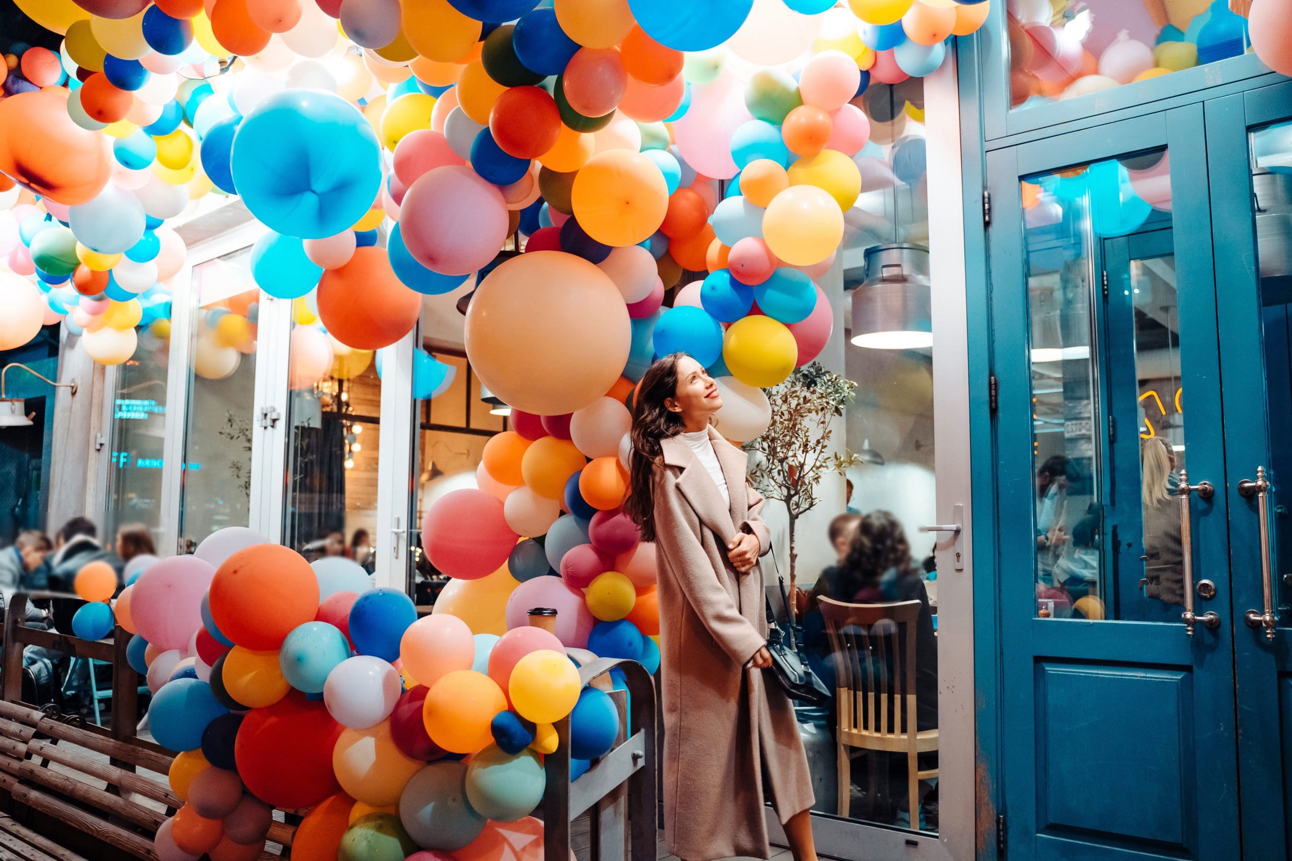 woman enjoying balloon decor at a small business with blue door that has a website and is found in local search